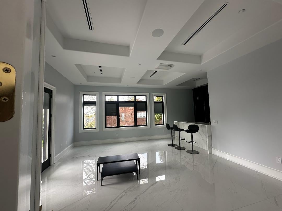 Empty modern office space with white walls, polished floor, windows, minimal furniture, and recessed lighting