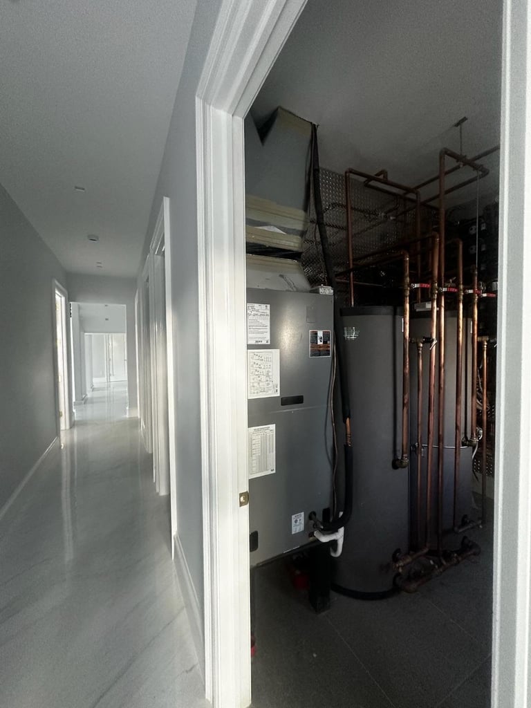 Interior hallway with white trim leading to a utility room containing a water heater and mechanical equipment